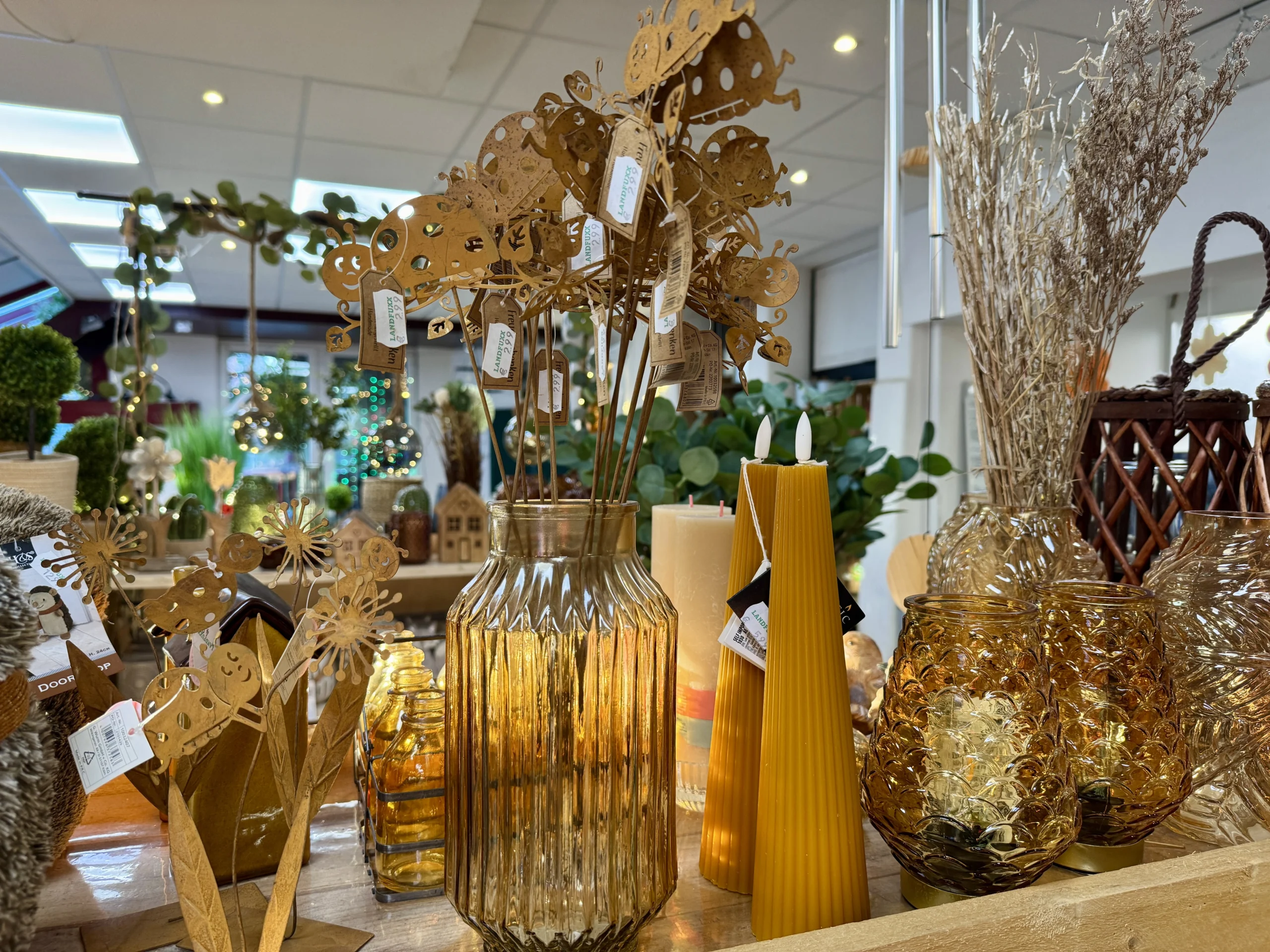 Schöne Deko, wie Vasen, Teelichter und Kerzen in warmen Farben im Landfuxx.