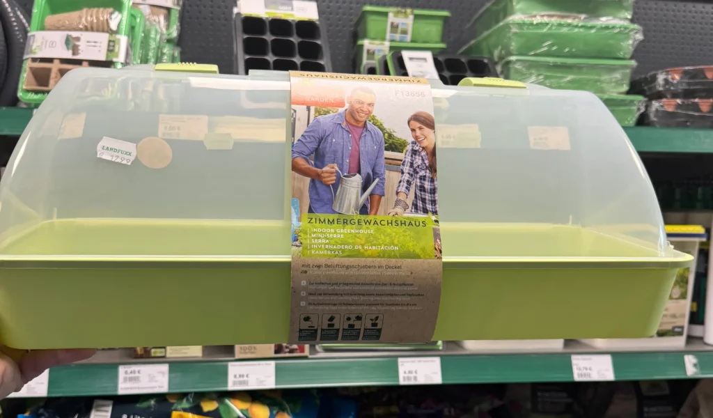 Zimmergewächshaus aus Kunststoff in grün mit durchsichtigem Deckel.